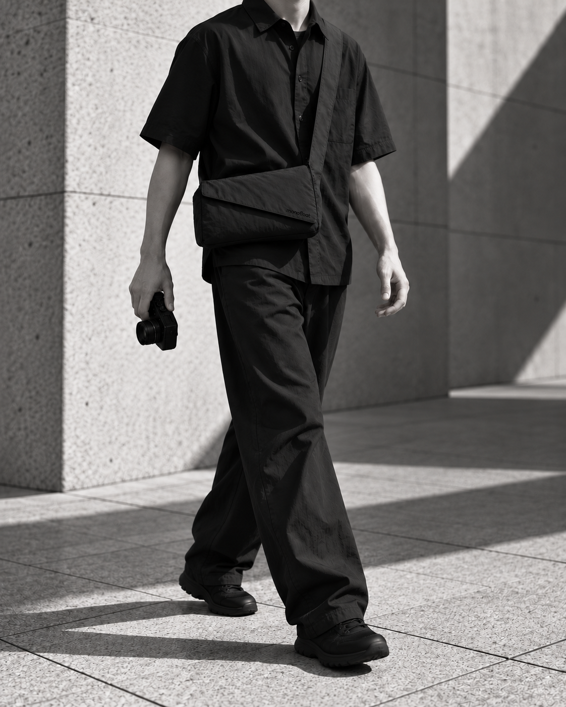 A street photographer carrying the compact Monofloat bag across the body.